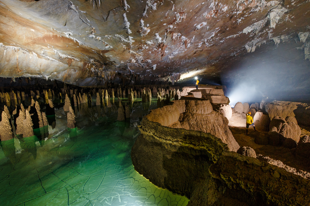 A caver stands amongst unique cave formations in Hang Va, Phong Nha Ke Bang, Vietnam